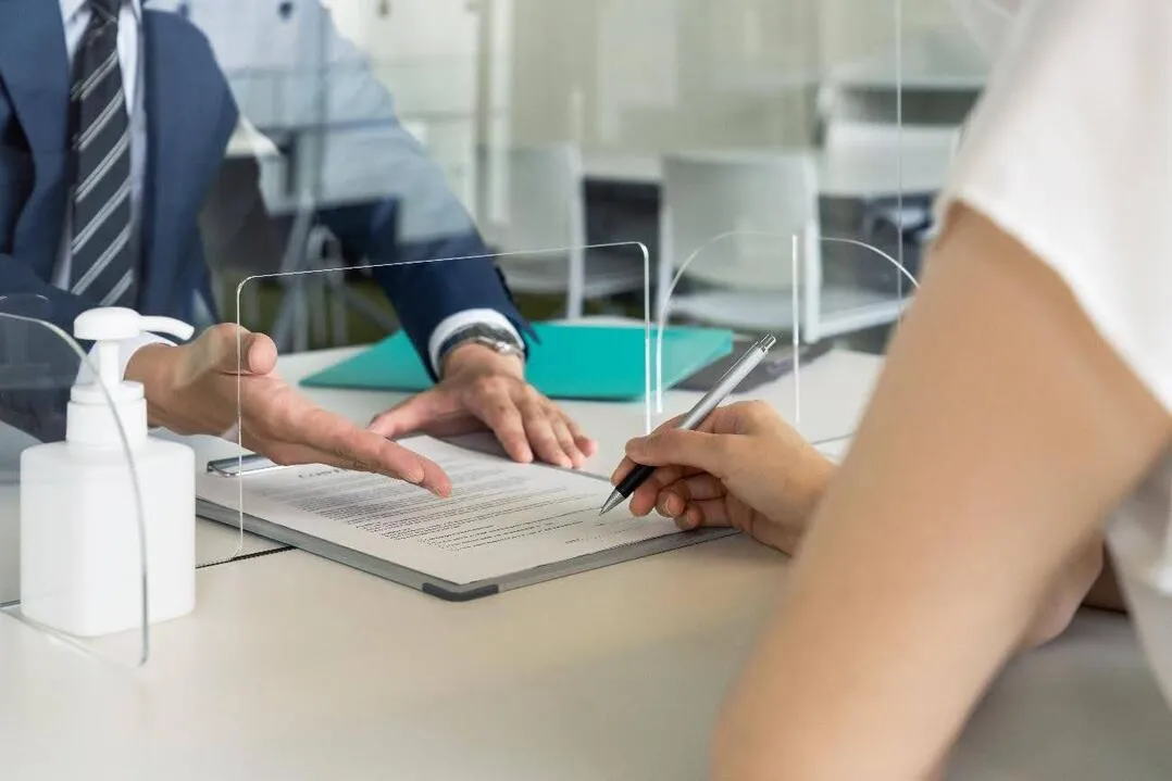 教育訓練休暇給付金の申請をイメージした、書類確認と署名の様子