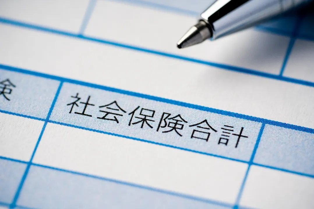 社会保険制度の理解を促す「社会保険合計」の文字が見える書類とペンの画像