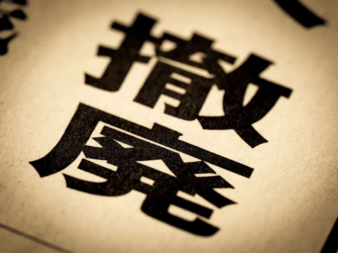 年収106万円の壁の撤廃を象徴する「撤廃」の文字が印刷された紙のクローズアップ画像