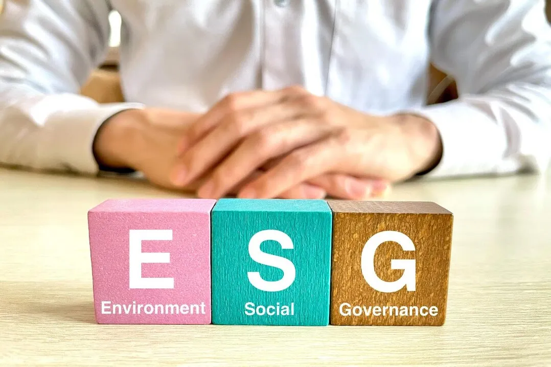 環境・社会・ガバナンス（ESG）を象徴するブロックが並ぶ写真。企業の規制違反リスクを示唆